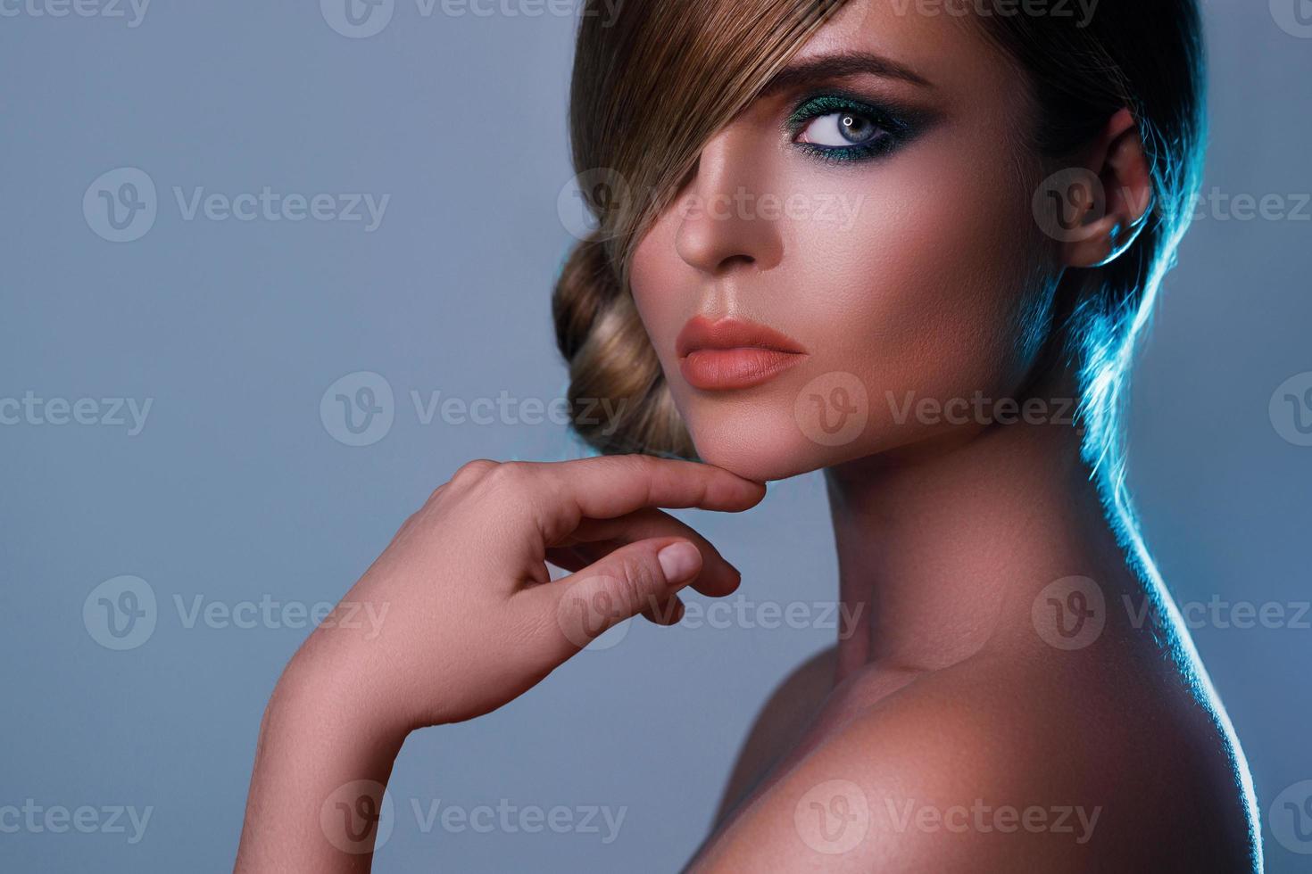 modèle sexy dans une image élégante avec des cheveux lisses couvrant un œil et de belles ombres à paupières vertes sur un autre photo