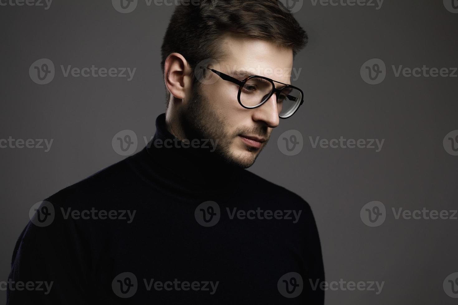 jeune homme intelligent portant des lunettes et un col polo plié photo