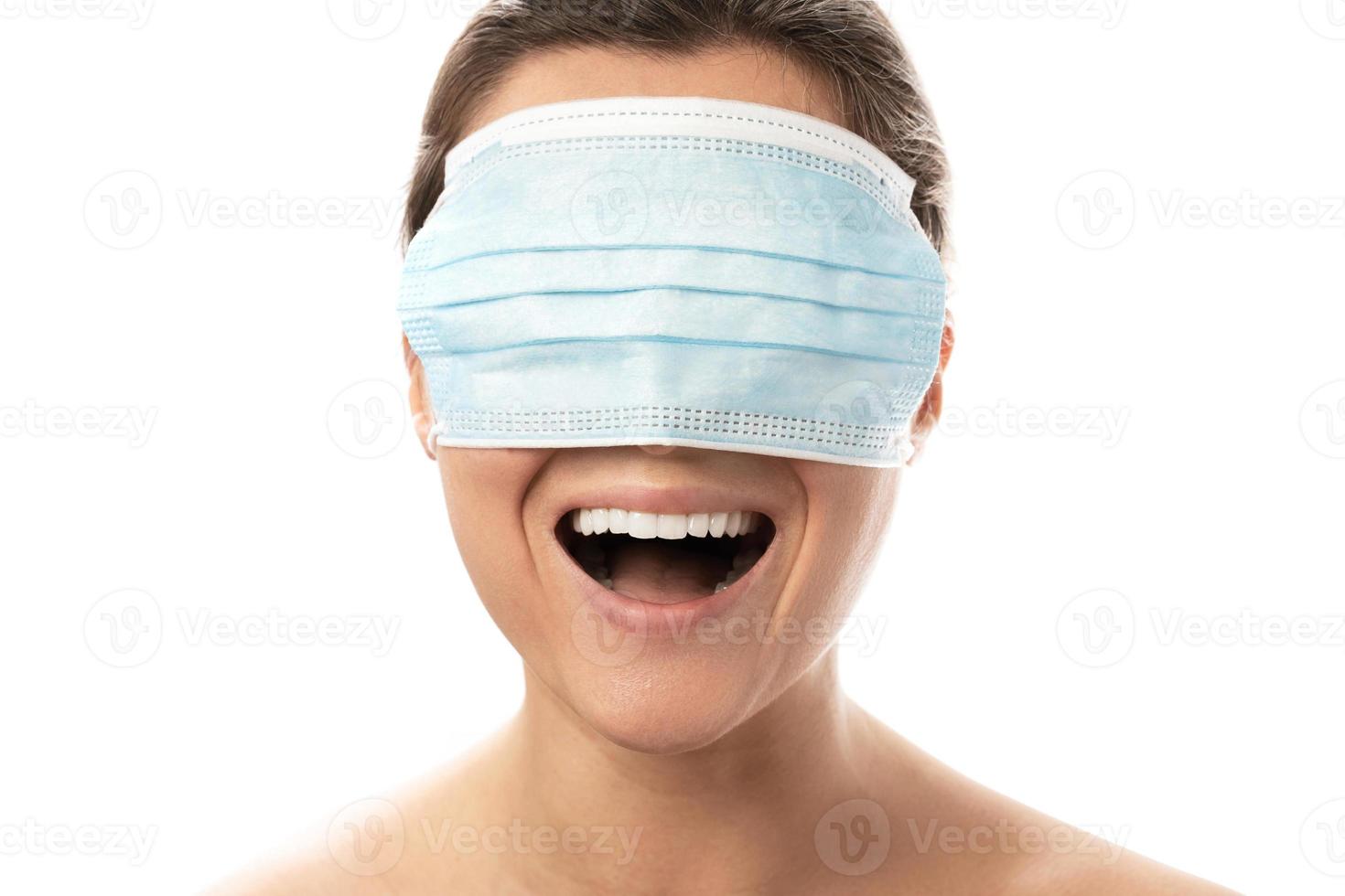 heureuse femme souriante portant un masque sur les yeux photo