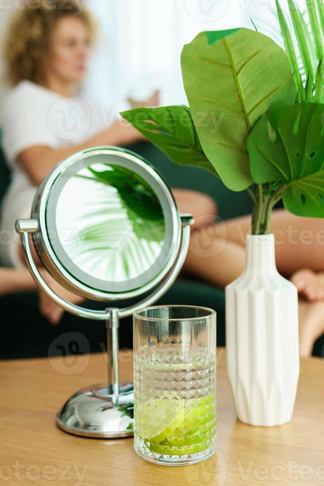 miroir rond et verre d'eau détox sur table photo