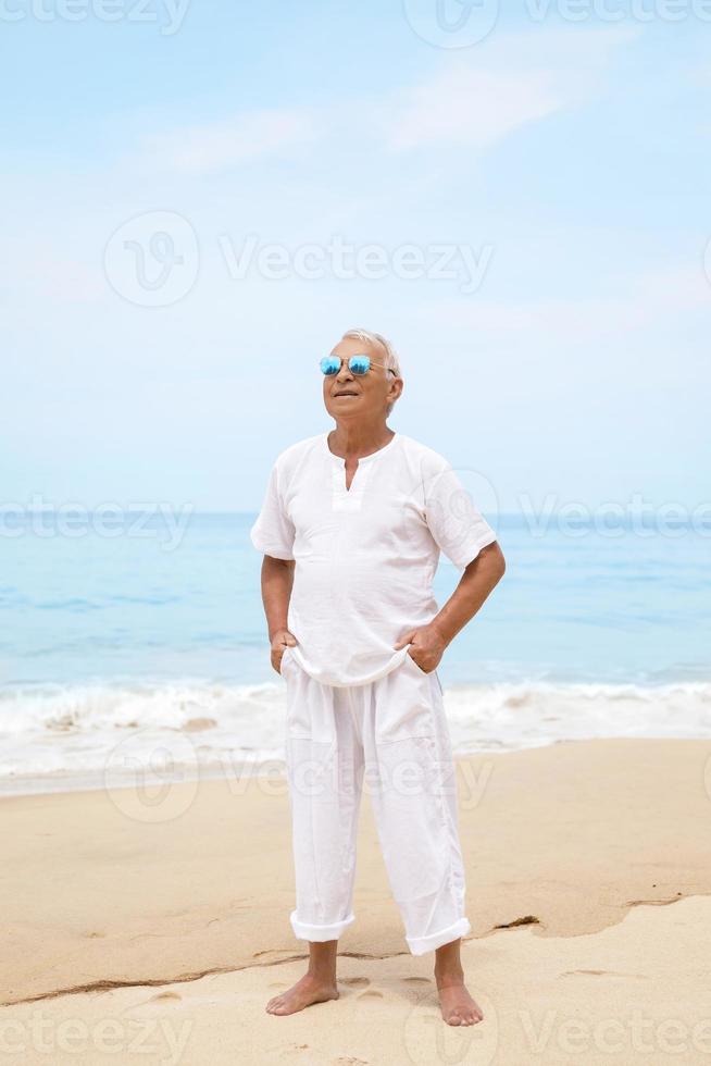 heureux homme âgé marchant sur la plage photo