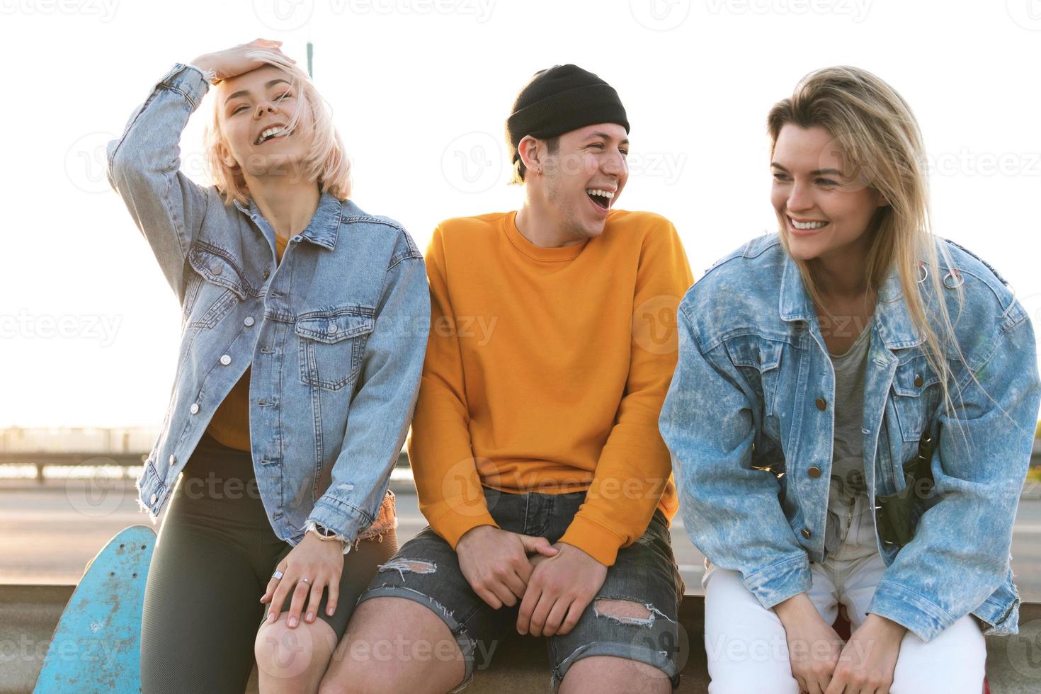 trois amis positifs rient dans une rue photo