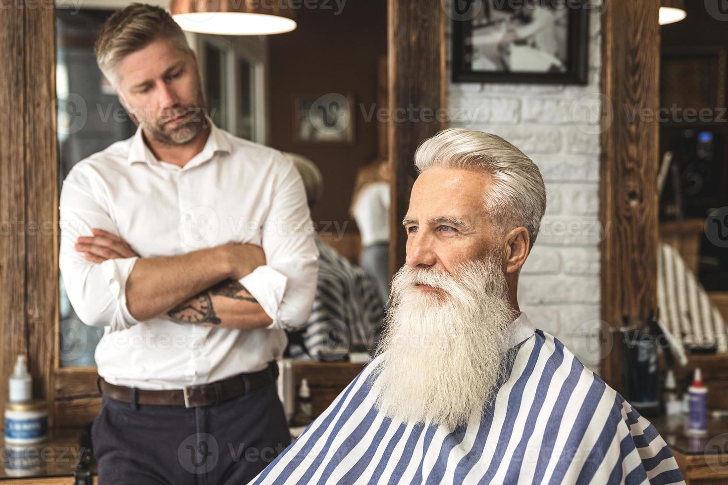 coiffeur heureux et client dans le salon de coiffure photo