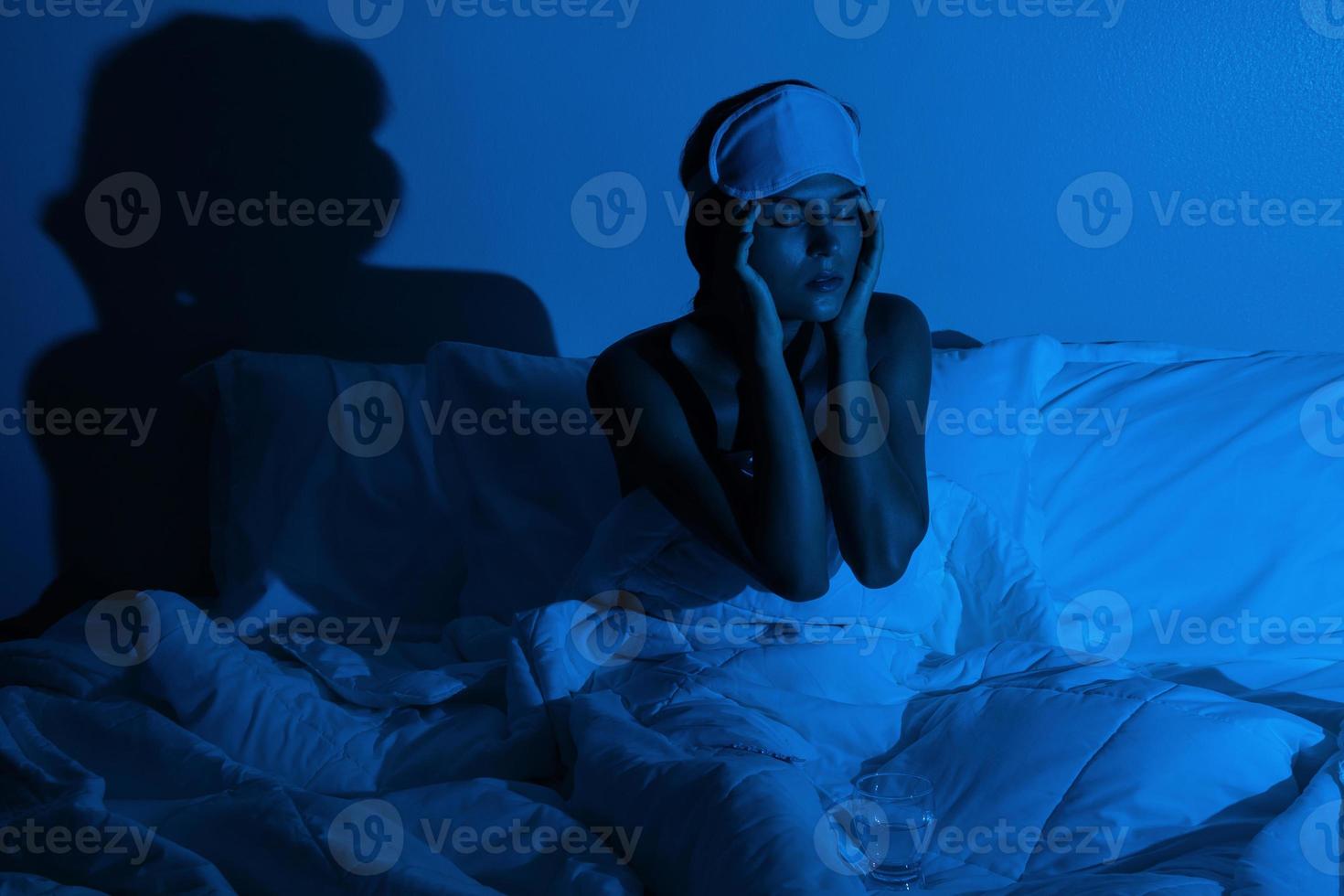 femme dans la chambre avec un verre d'eau et des somnifères photo