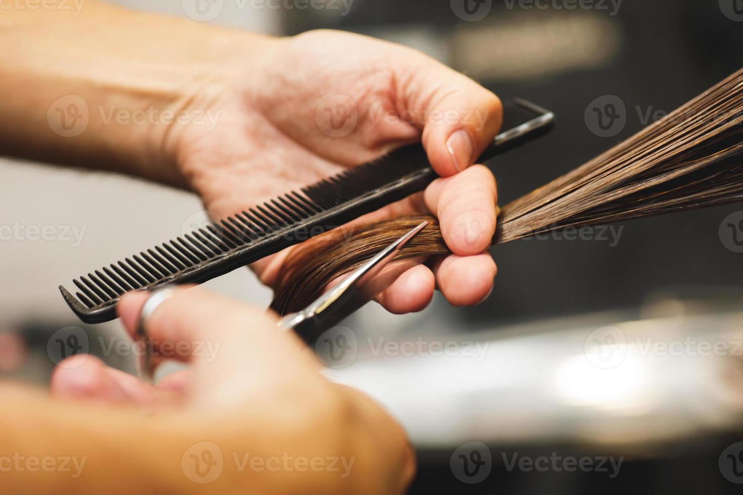 coiffeur mains masculines pendant la coupe des cheveux féminins photo