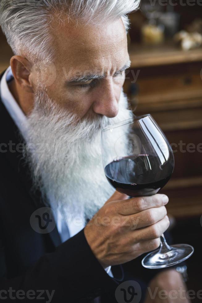 bel homme âgé barbu buvant du vin rouge photo