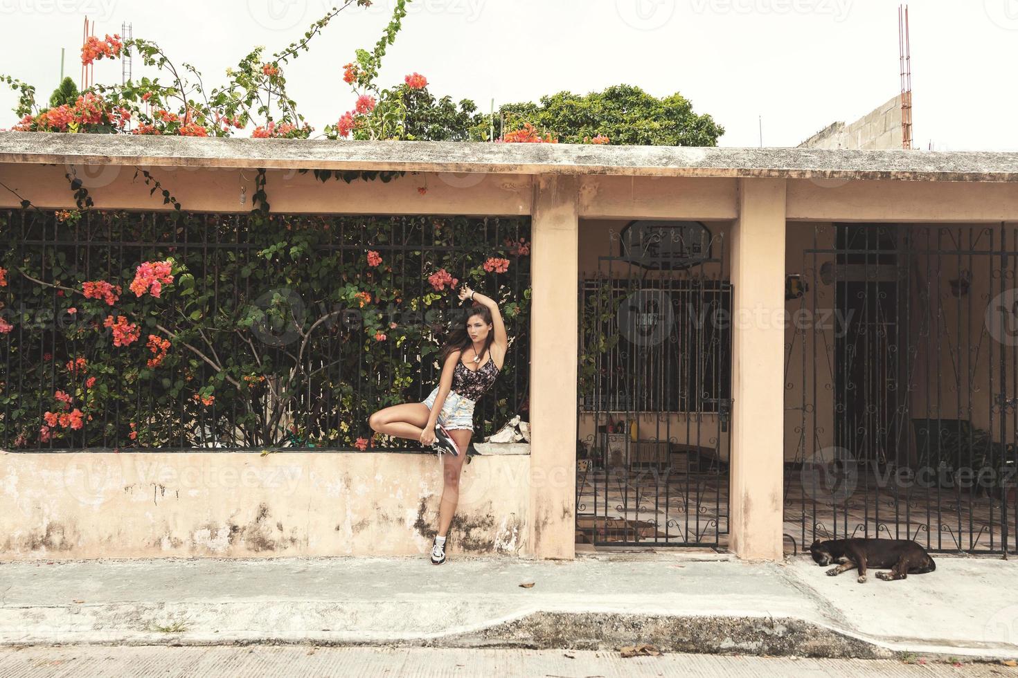 femme sexy à côté de la maison avec une haie pleine de fleurs photo