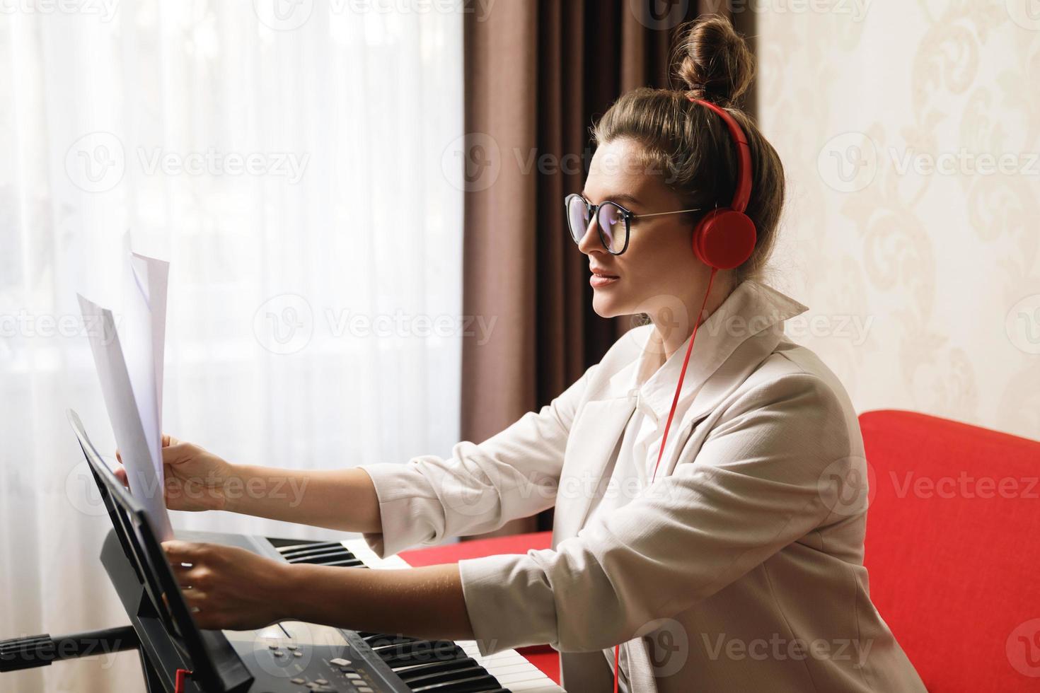 jeune femme musicienne jouant du synthétiseur à la maison photo