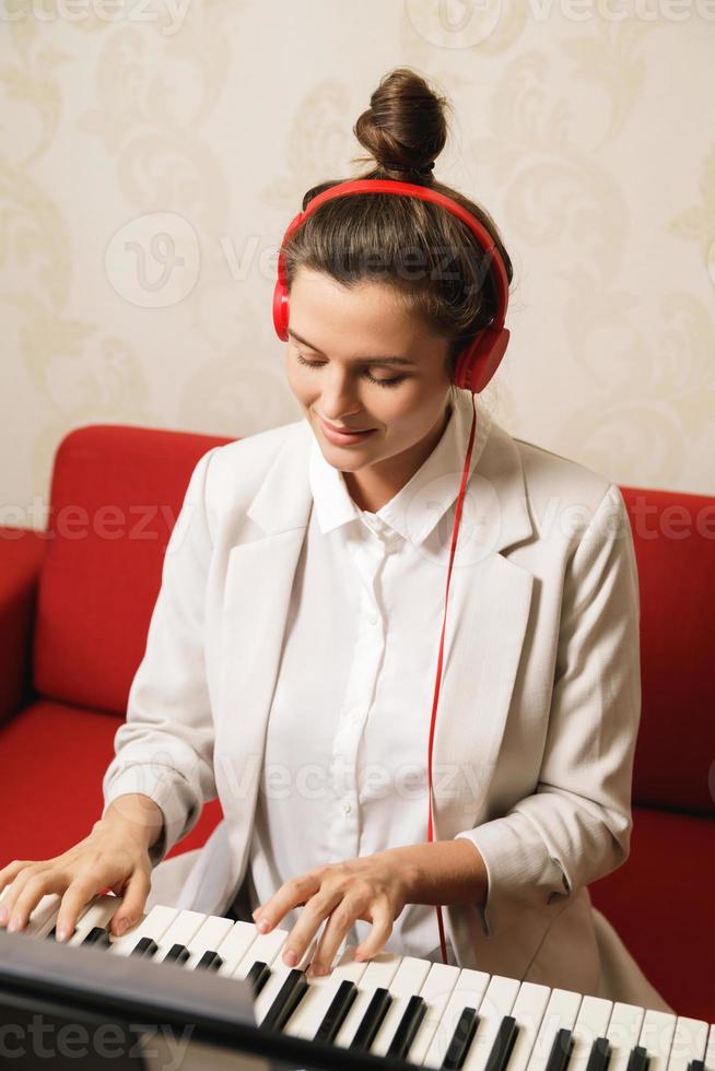 jeune femme musicienne jouant du synthétiseur à la maison photo