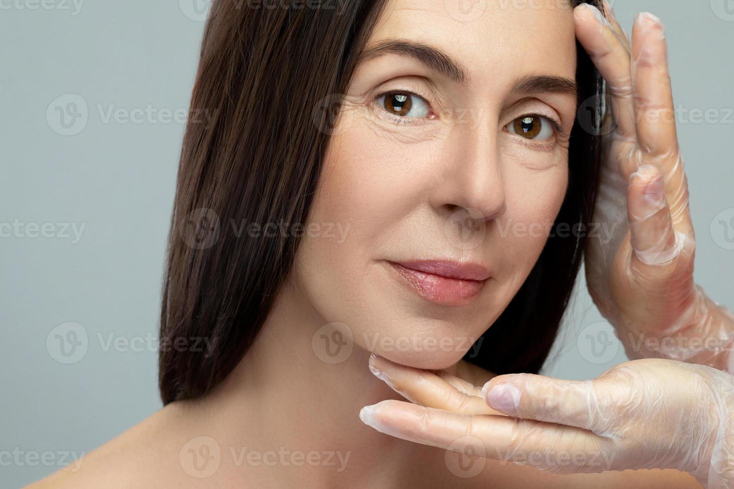 femme d'âge moyen recevant un examen par une esthéticienne professionnelle. photo