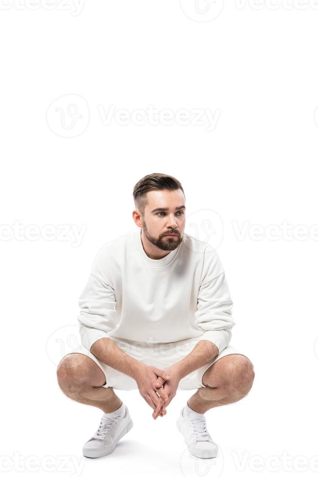 bel homme portant un sweat-shirt blanc et un short sur fond blanc photo