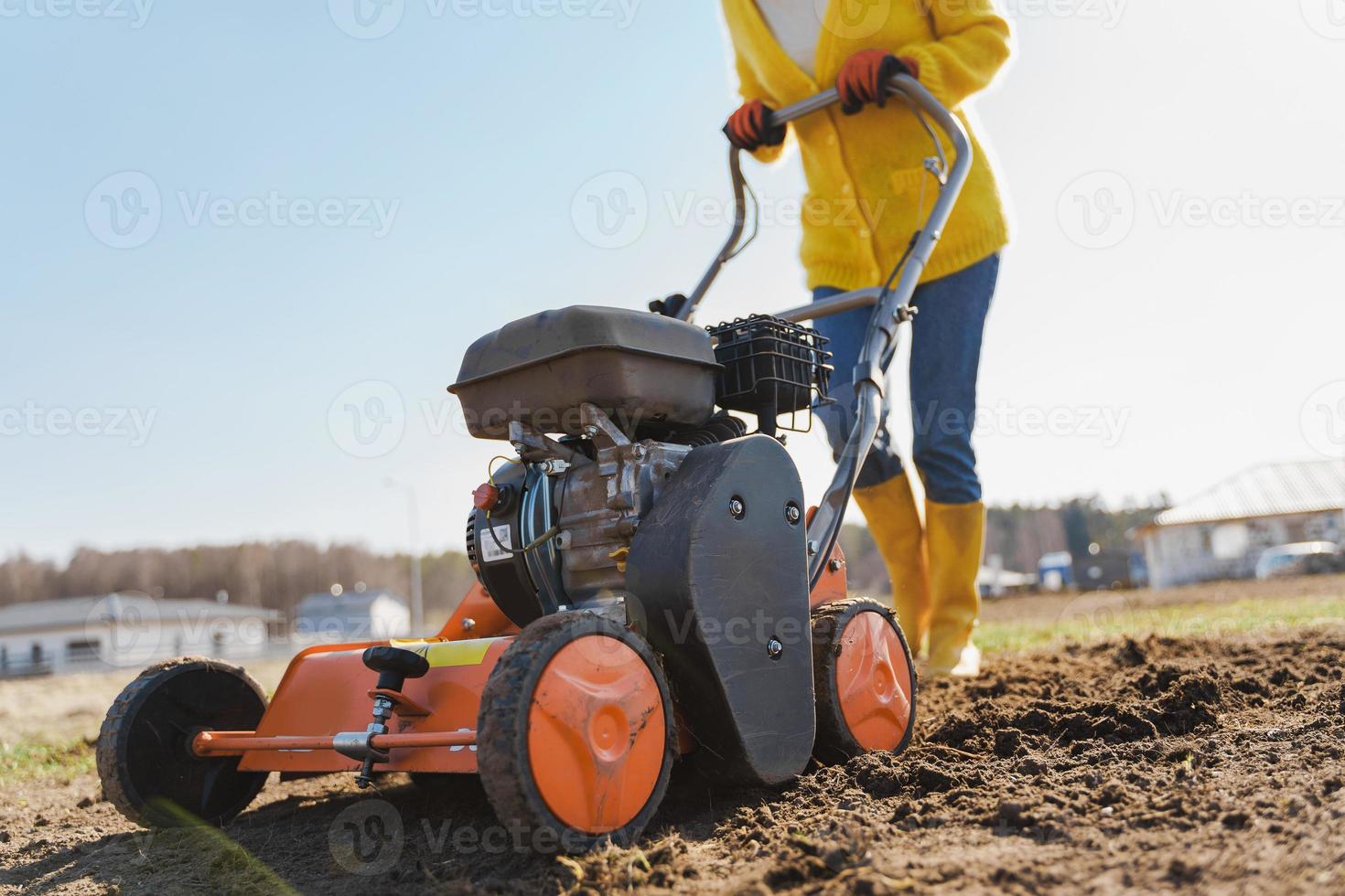 une villageoise utilise un aérateur pour la scarification et l'aération de la pelouse ou du pré photo