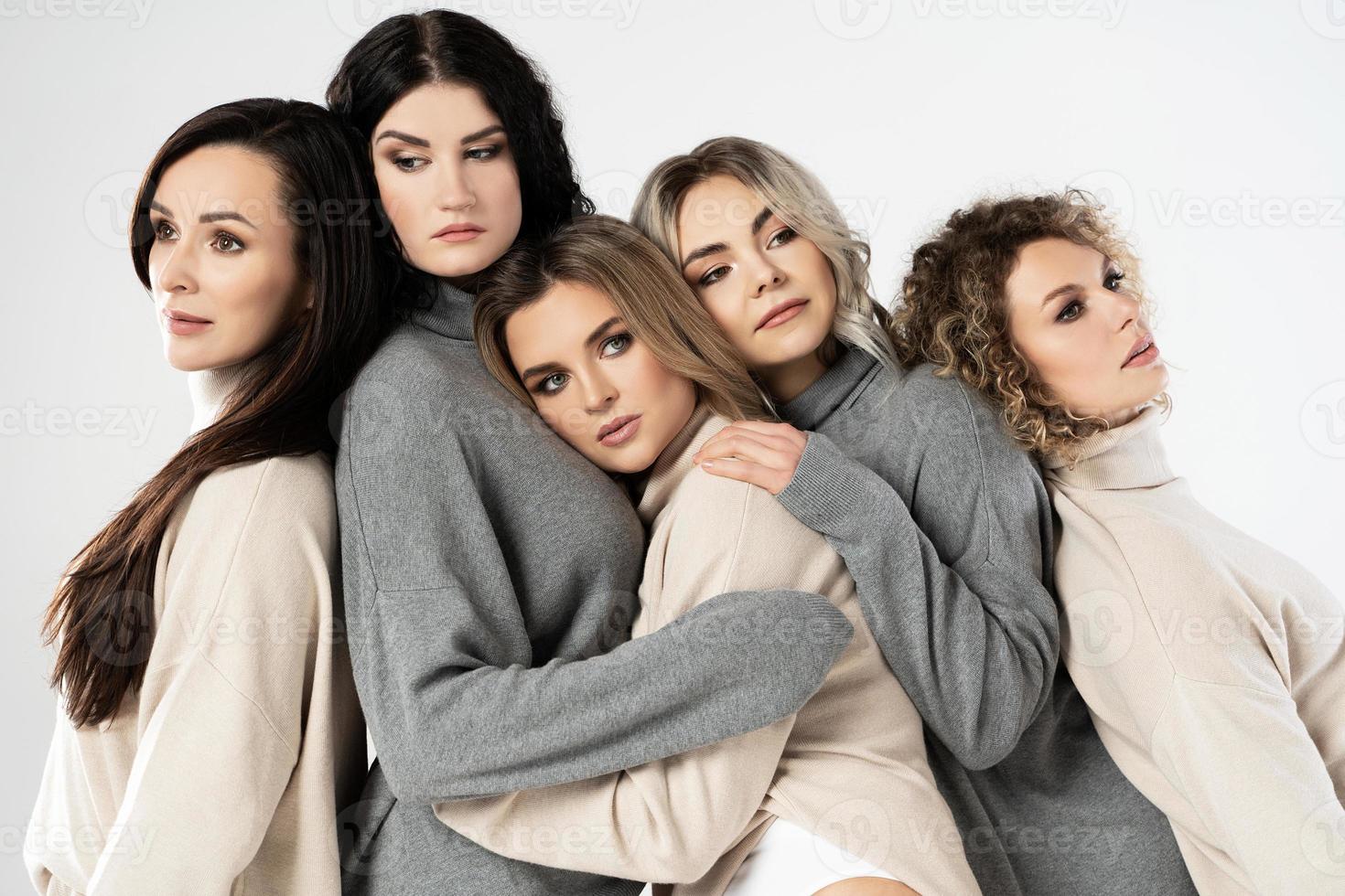 groupe de femmes différentes portant des pulls à col roulé sur fond gris photo