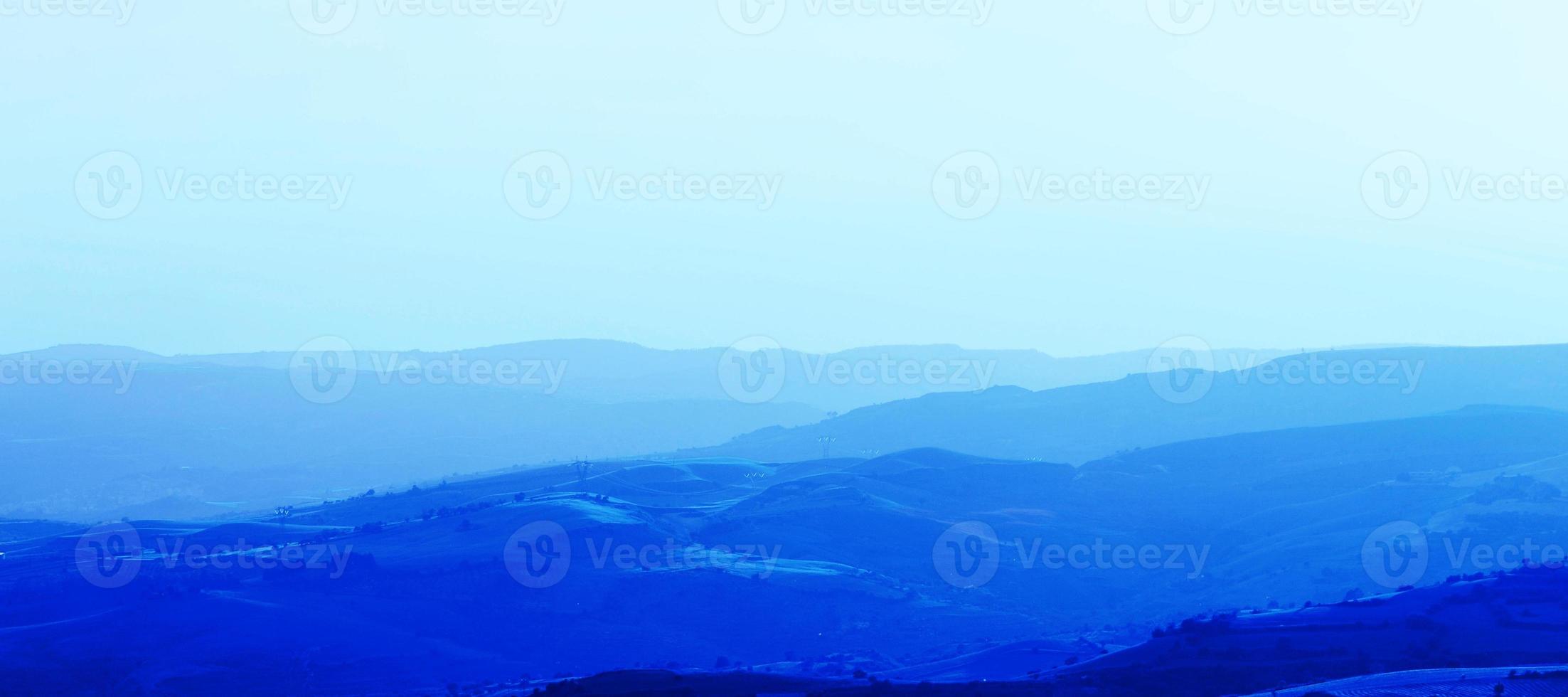 couches de chaînes de montagnes empilées en silhouette bleue. perspective aérienne des collines bleues. photo