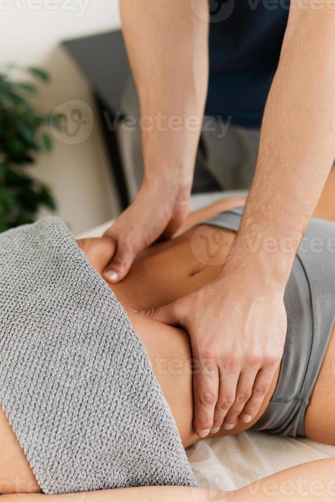 gros plan des mains de l'homme masseur pendant le massage de l'estomac photo