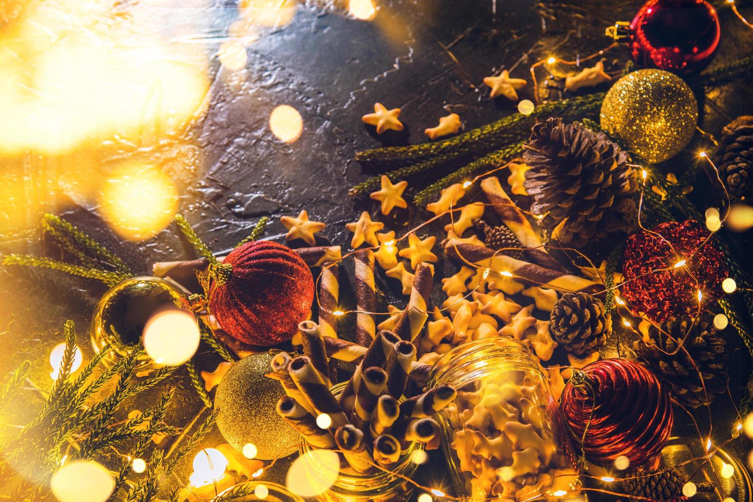 boules de décoration de noël avec des biscuits et des pâtisseries sur fond noir abstrait bokeh avec espace de copie et lumières LED décoratives. joyeux noël et nouvel an. carte de voeux. photo