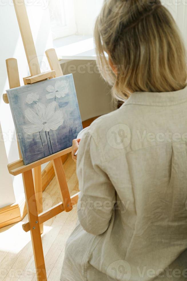 jeune femme artiste peignant sur toile sur le chevalet photo