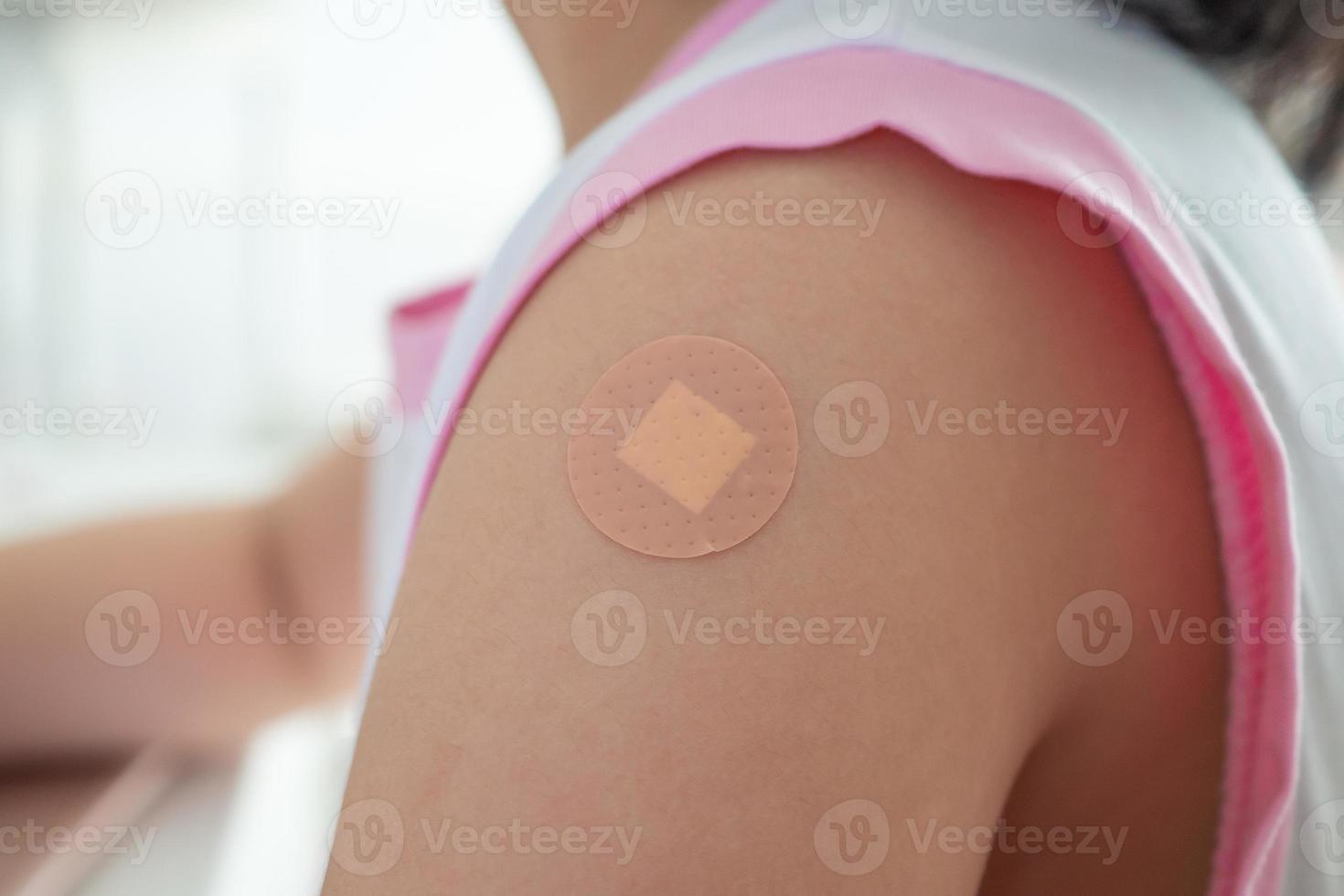 petite fille asiatique vaccinée avec pansement adhésif après injection de vaccin photo