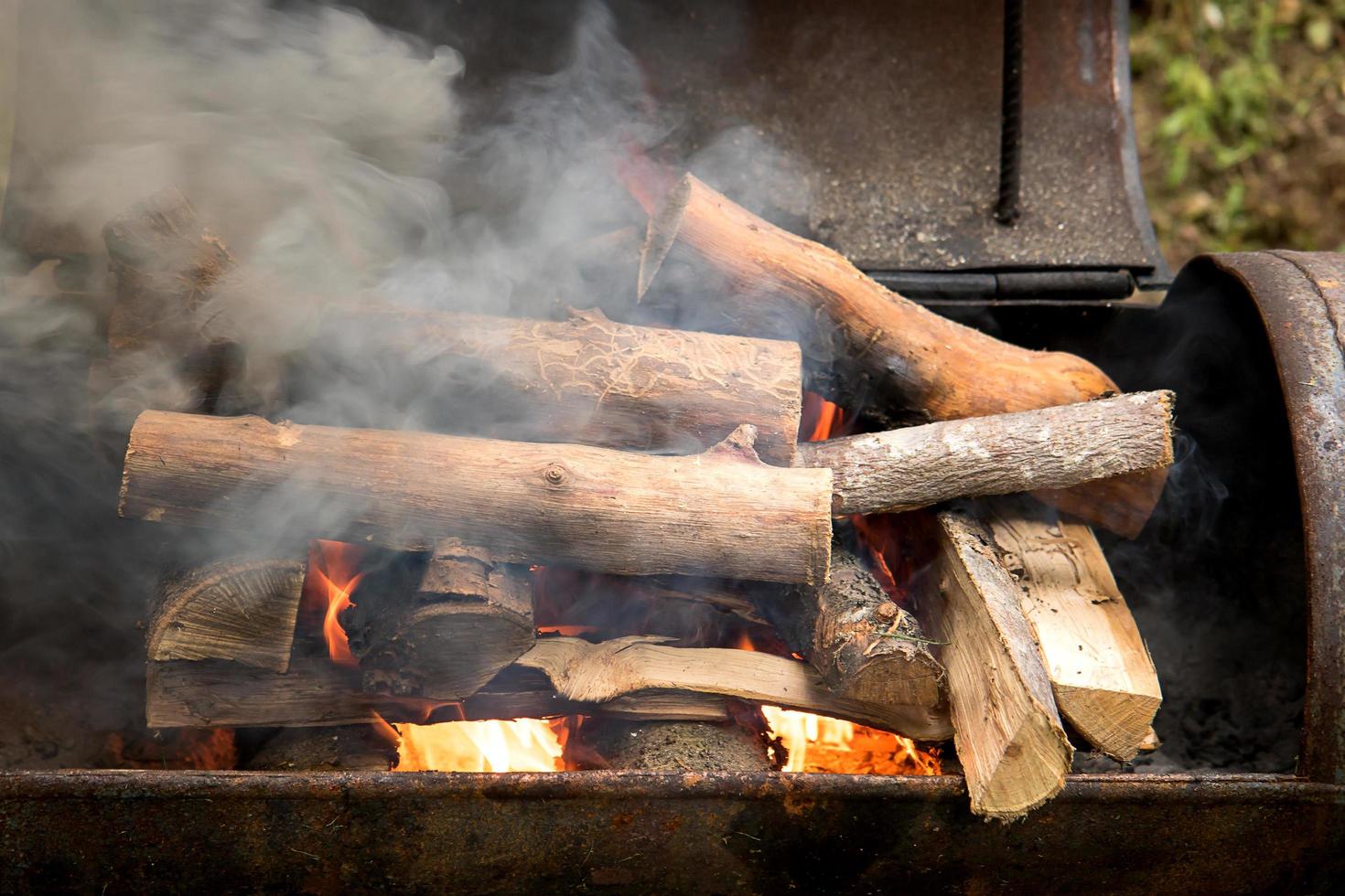 brûler du bois de chauffage dans un brasier en fer, de la fumée et du feu photo