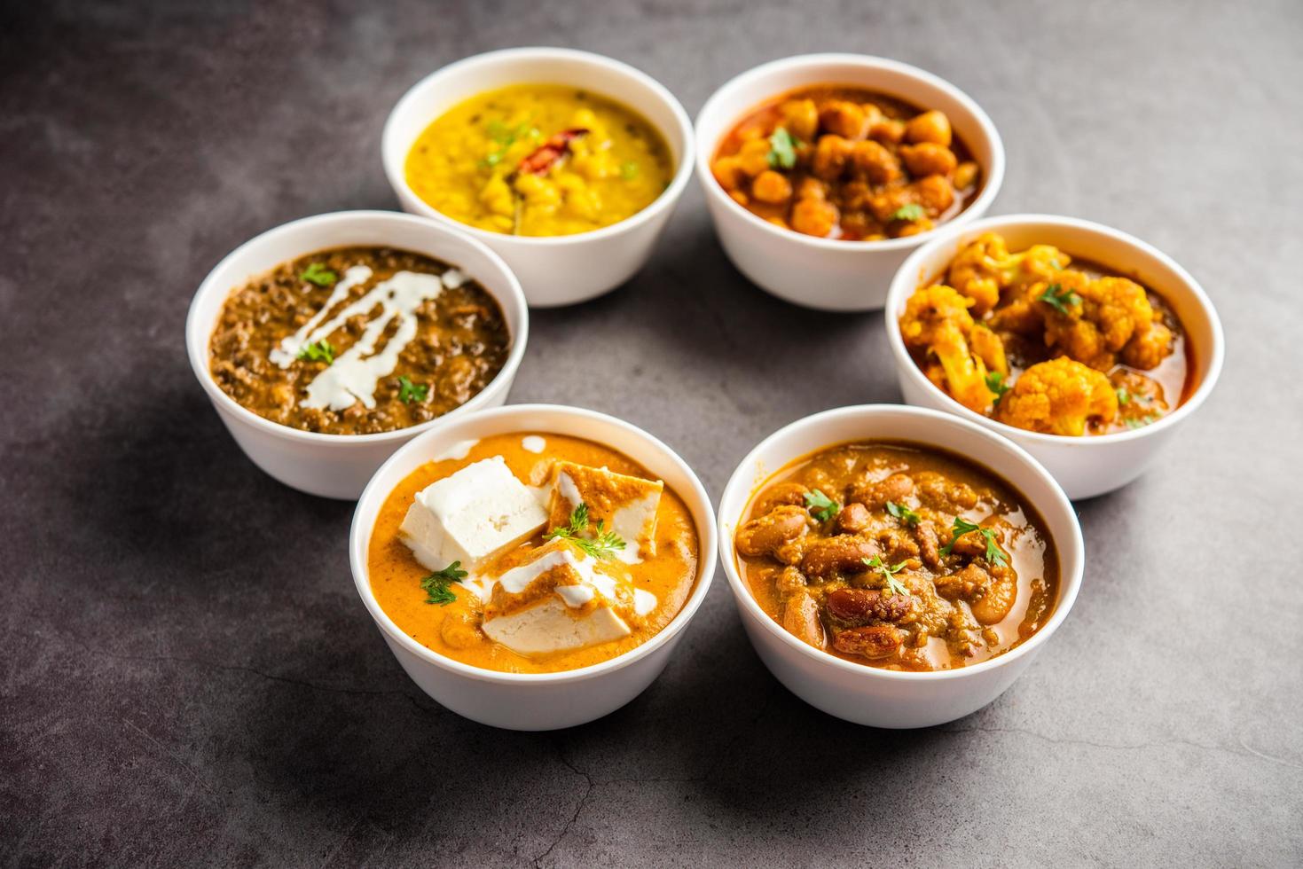 groupe de plats végétariens indiens, assortiment de plats de cuisine punjabi chauds et épicés dans des bols photo