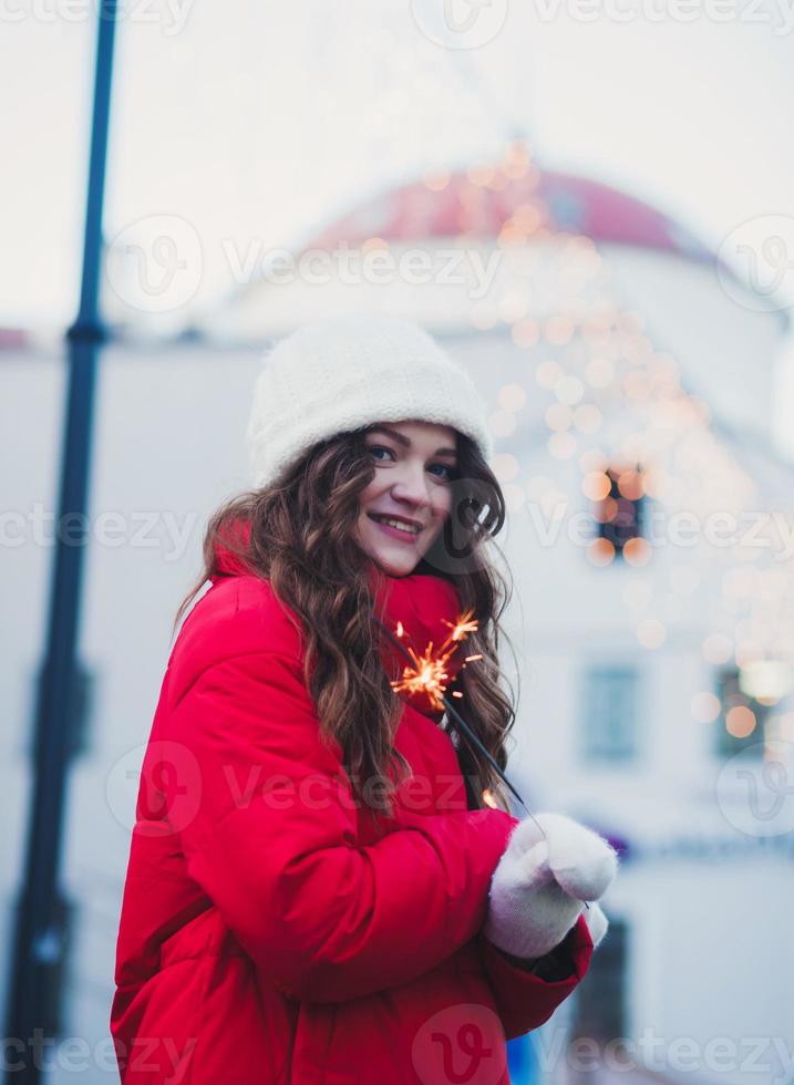 femme en vêtements d'hiver tenant des feux de bengale photo