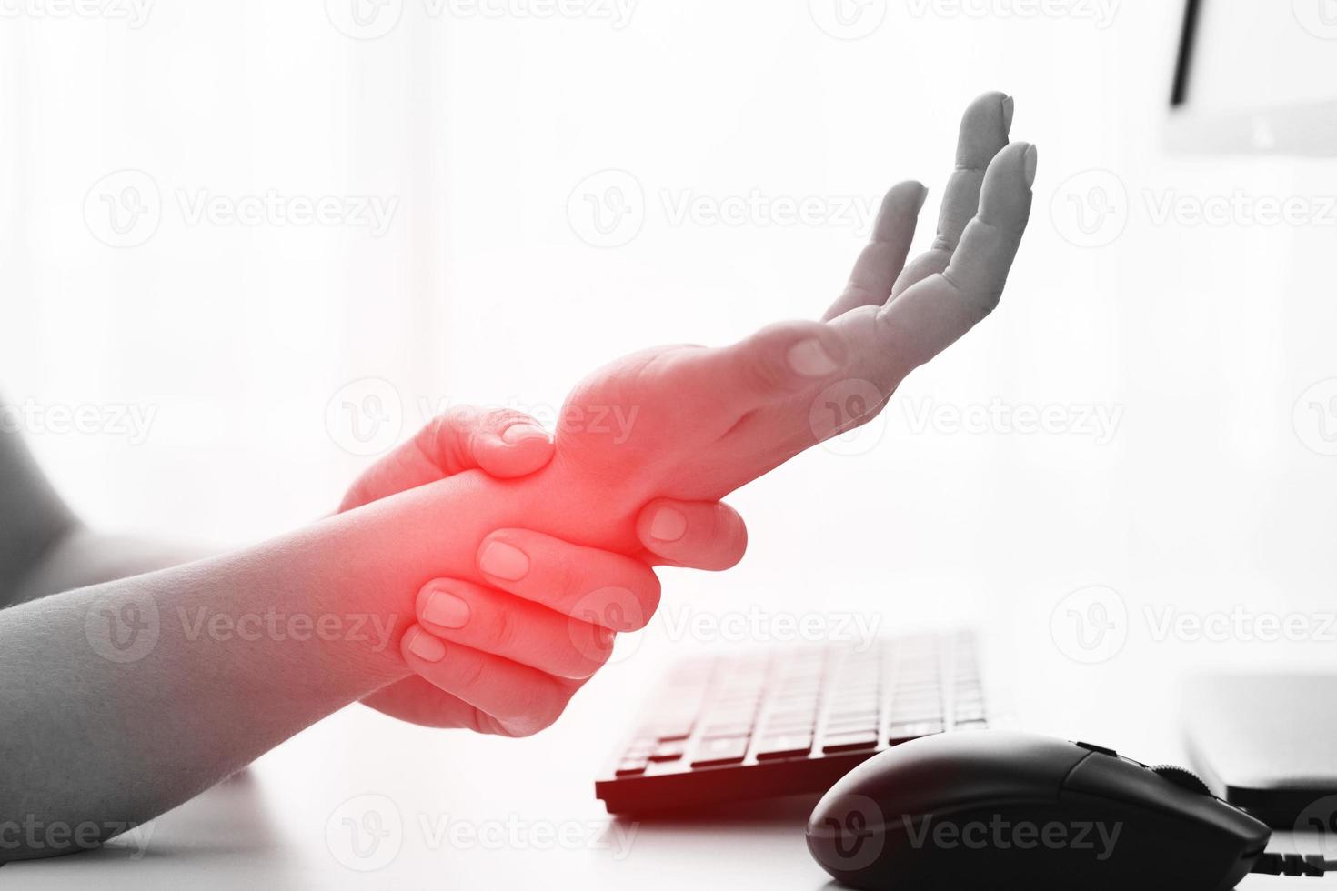 femme travaillant au bureau avec un syndrome du canal carpien ou une inflammation de l'articulation du poignet photo