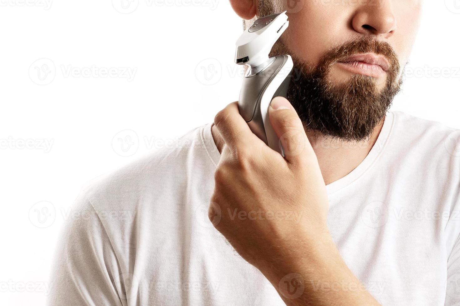 homme barbu utilise une tondeuse électrique photo