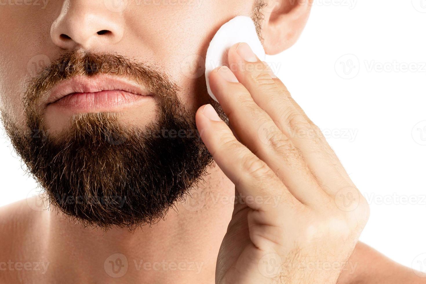 l'homme se nettoie le visage avec un coton photo