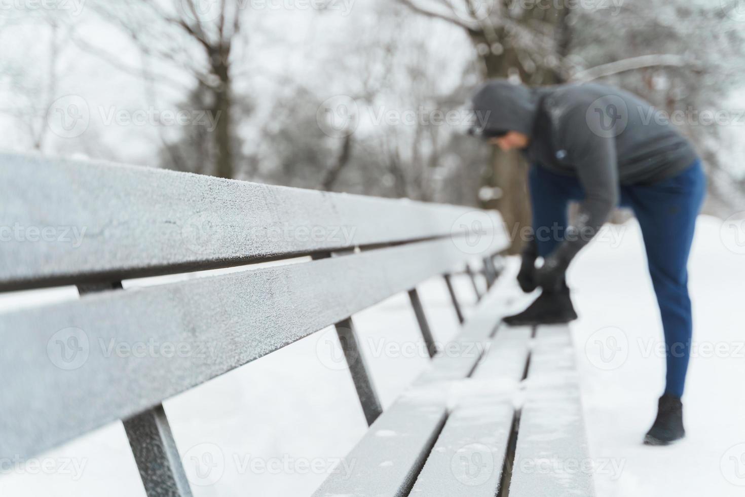 un jogger lace ses chaussures pendant son entraînement d'hiver photo