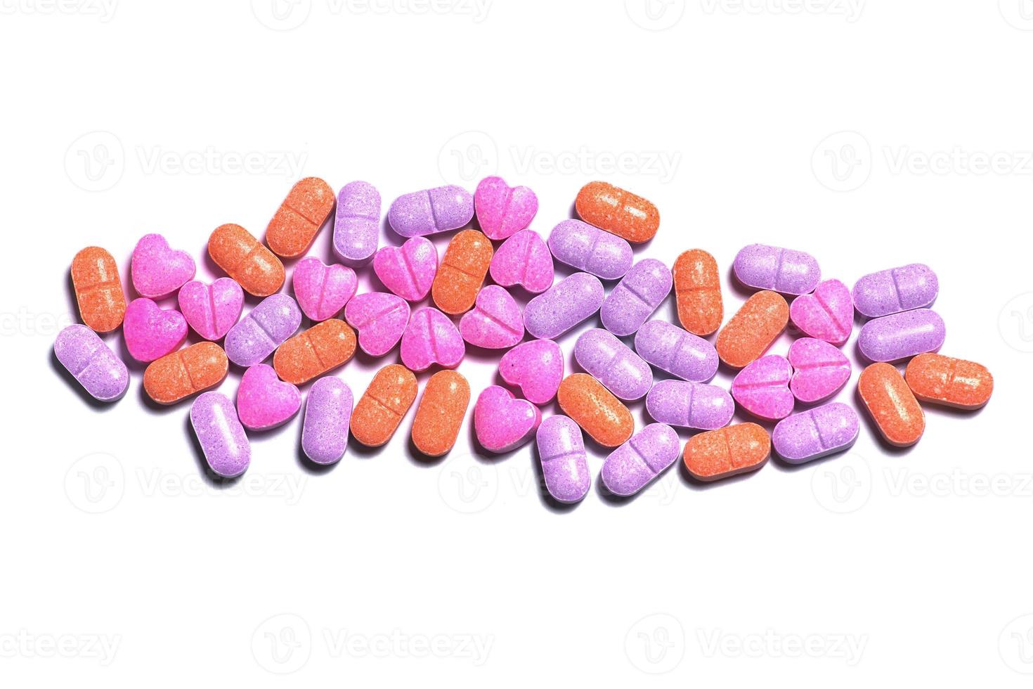 gros plan d'un tas de pilules colorées sur fond blanc. photo