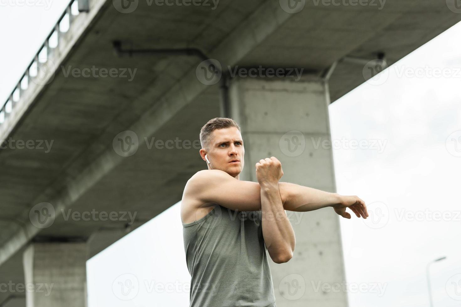 homme musclé s'échauffant avant son entraînement de fitness en plein air photo