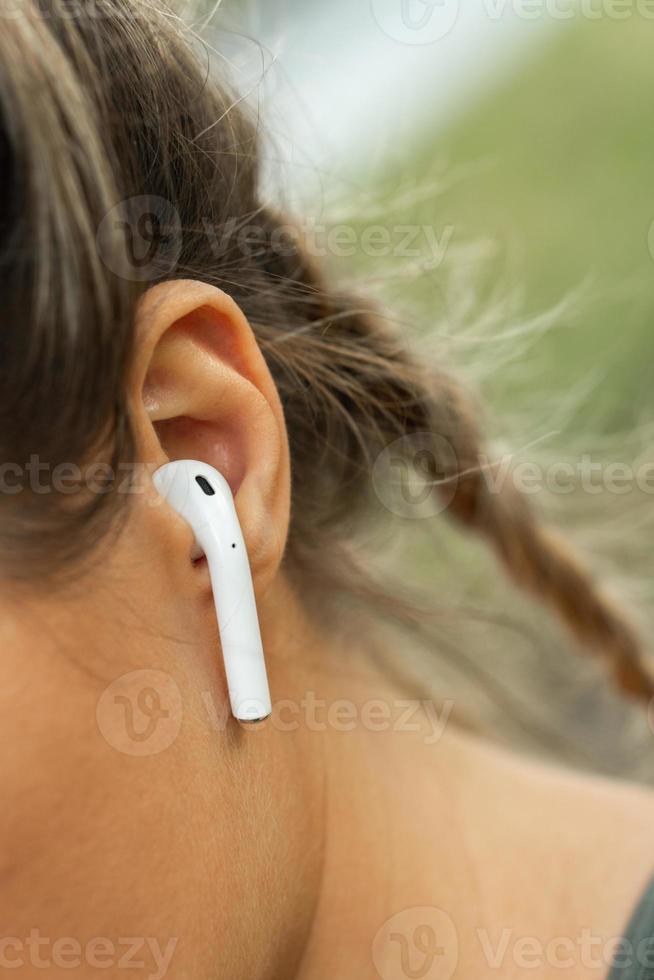 gros plan de l'oreille féminine avec écouteur sans fil photo