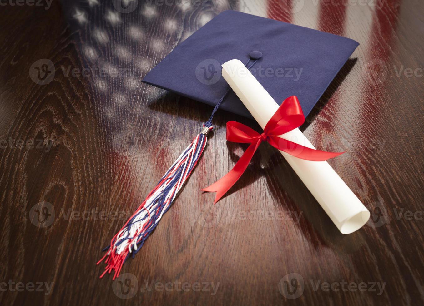 chapeau de graduation et diplôme sur table avec reflet du drapeau américain photo