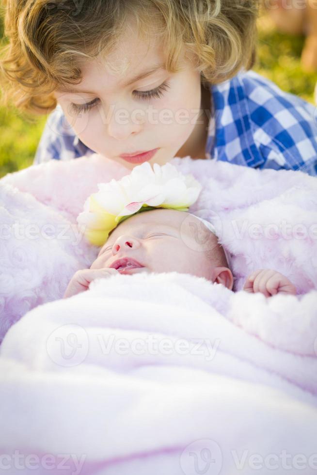 jeune garçon regardant sa petite soeur nouveau-née photo