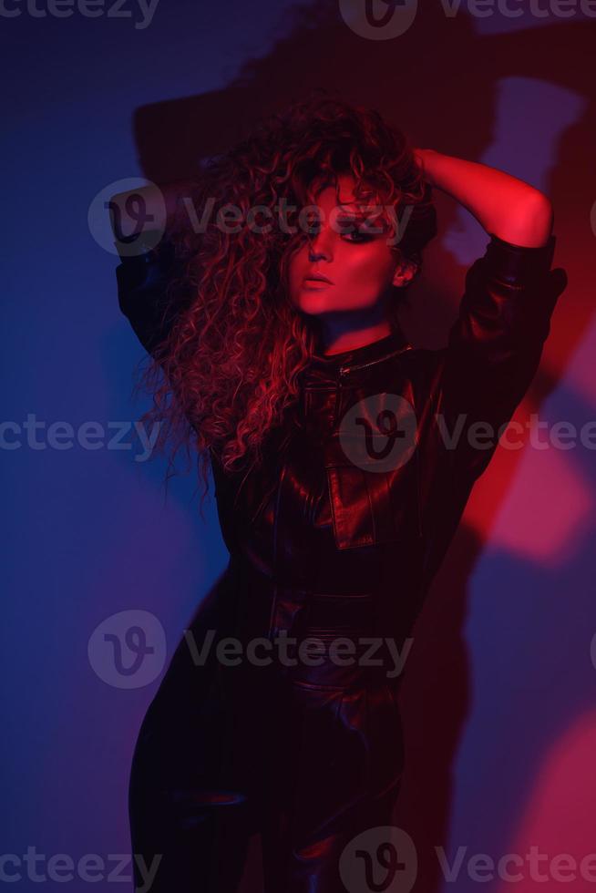 jeune et sexy femme avec une coiffure afro élégante portant un costume de motard en cuir photo