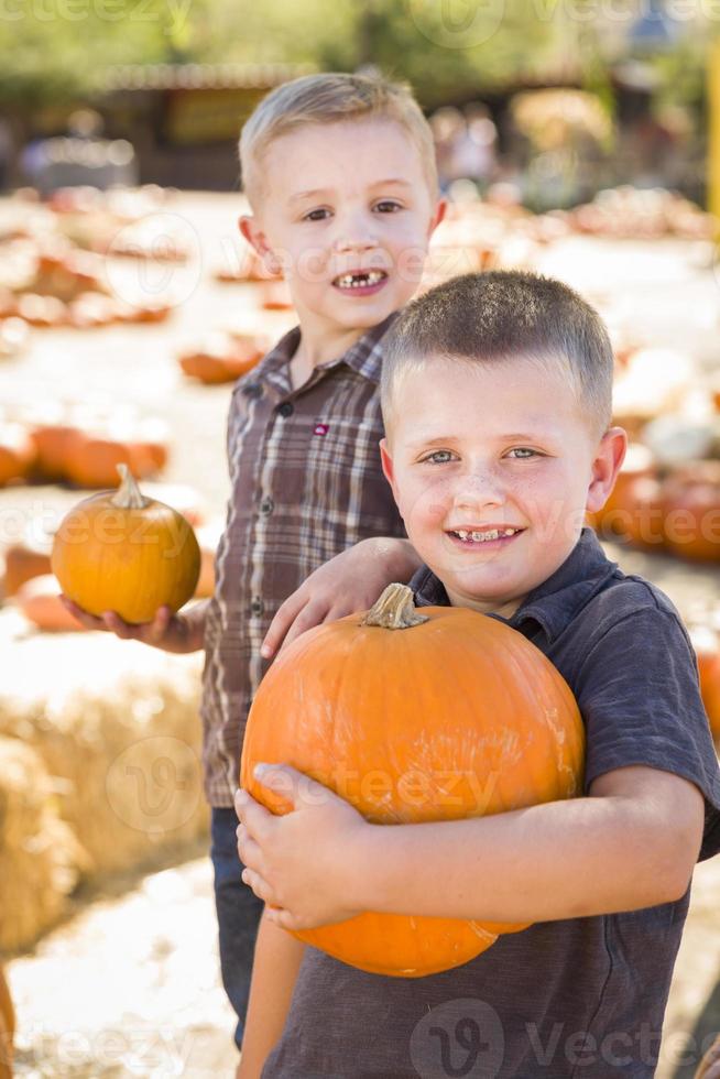 deux garçons s'amusant au champ de citrouilles un jour d'automne. photo