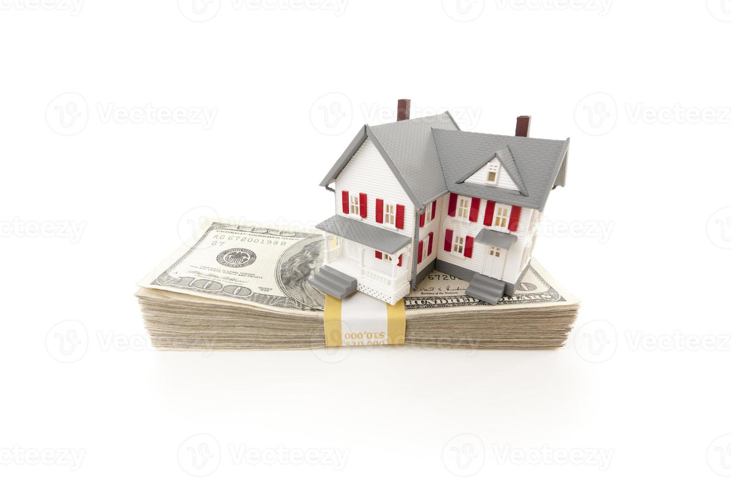 petite maison sur pile de billets de cent dollars photo