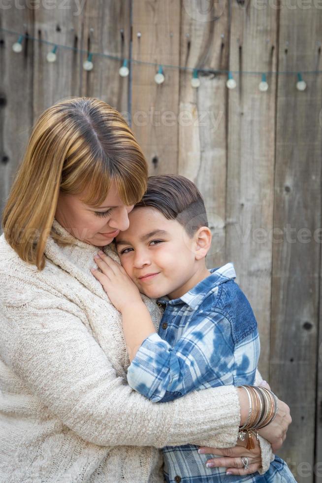 mère et fils métis s'embrassent près de la clôture photo