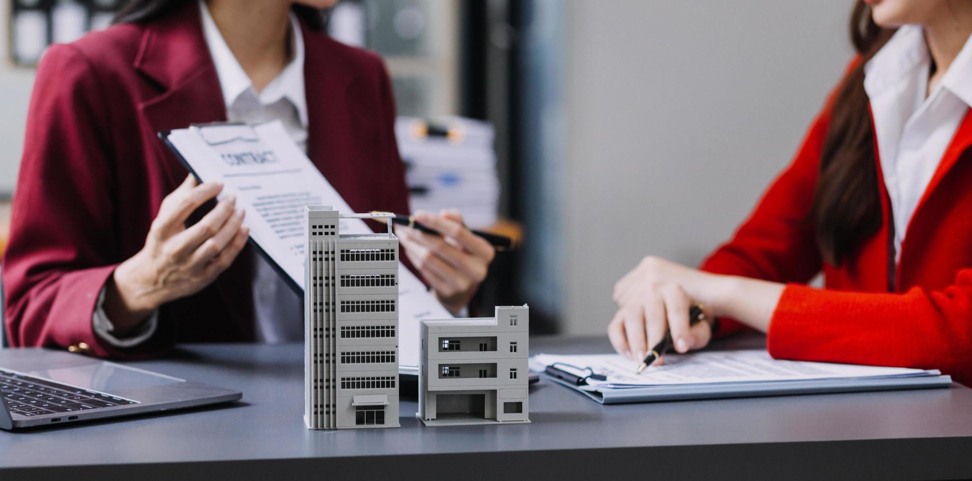 discussion avec un agent immobilier, modèle de maison avec agent et client discutant du contrat d'achat, d'assurance ou de prêt immobilier ou immobilier. photo