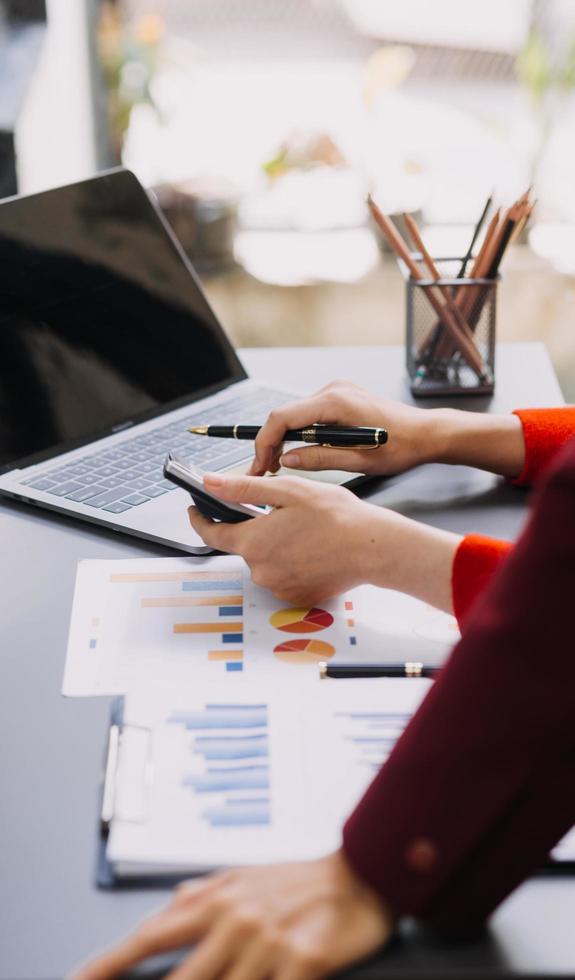 homme d'affaires et équipe analysant la tâche de financement des états financiers. avec téléphone intelligent et ordinateur portable et tablette. notion de gestion de patrimoine photo