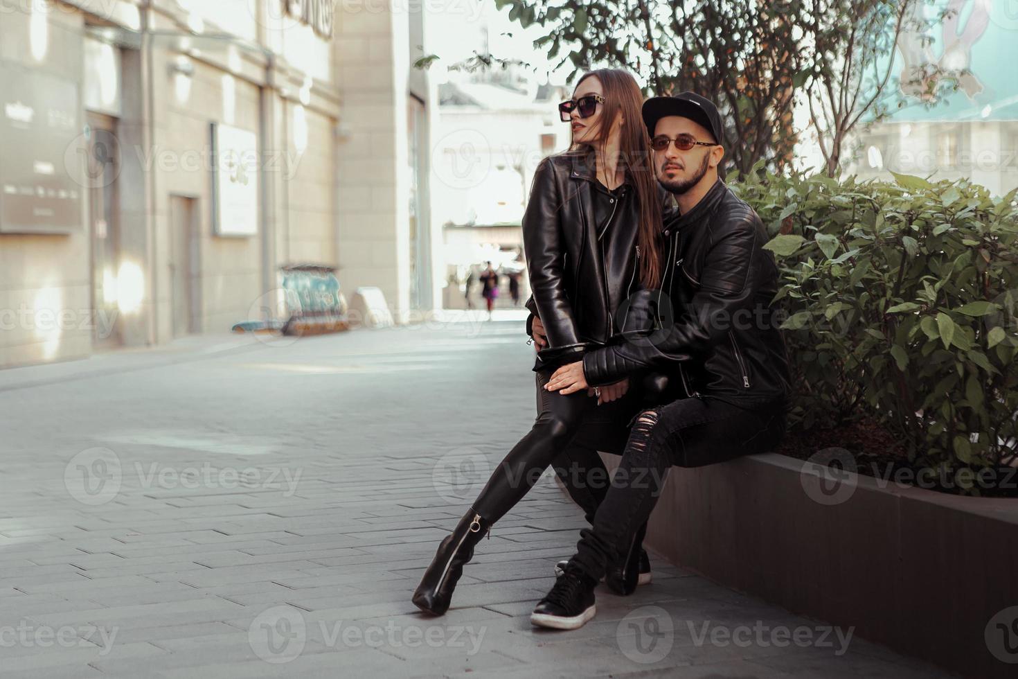couple sexy posant sur un banc et regarde ailleurs dans la rue photo
