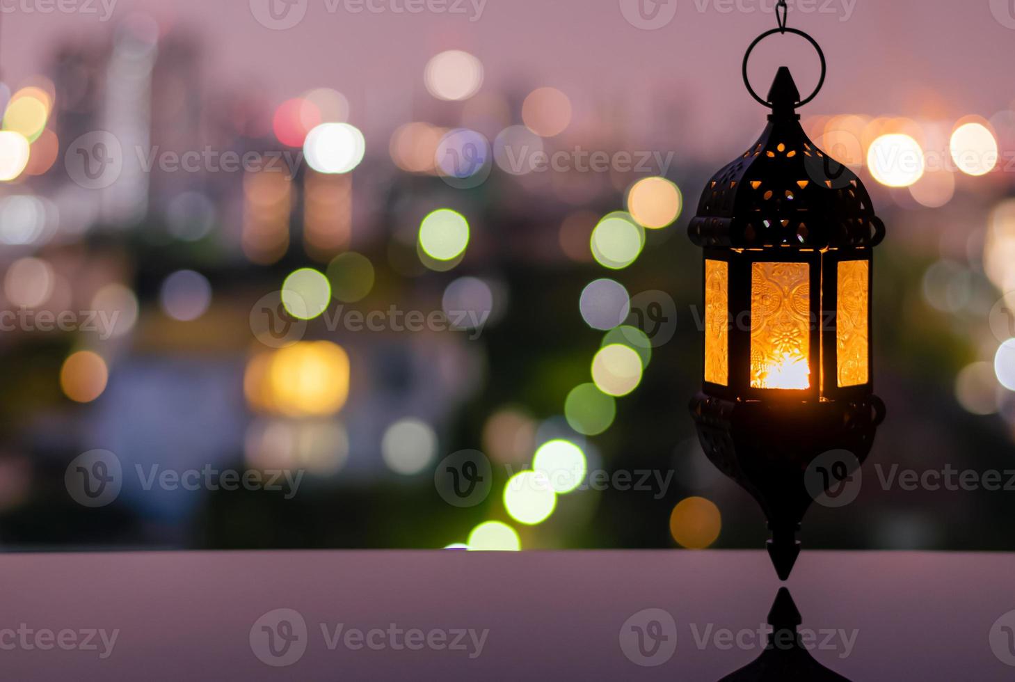 lanterne suspendue avec ciel nocturne et fond clair bokeh de la ville pour la fête musulmane du mois sacré du ramadan kareem. photo