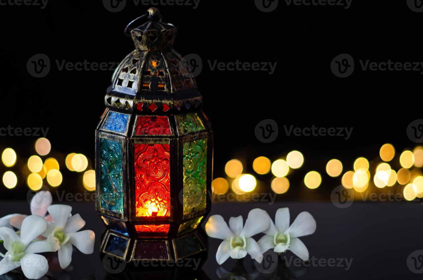 lanterne avec fleur d'orchidée blanche sur fond clair bokeh pour la fête musulmane du mois sacré du ramadan kareem. photo