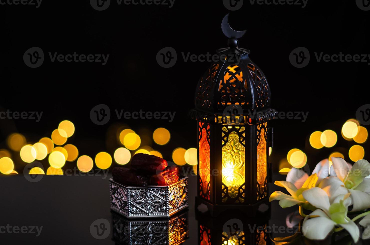 lanterne et fruits de dattes avec fleur d'orchidée blanche sur fond clair bokeh pour la fête musulmane du mois sacré du ramadan kareem. photo