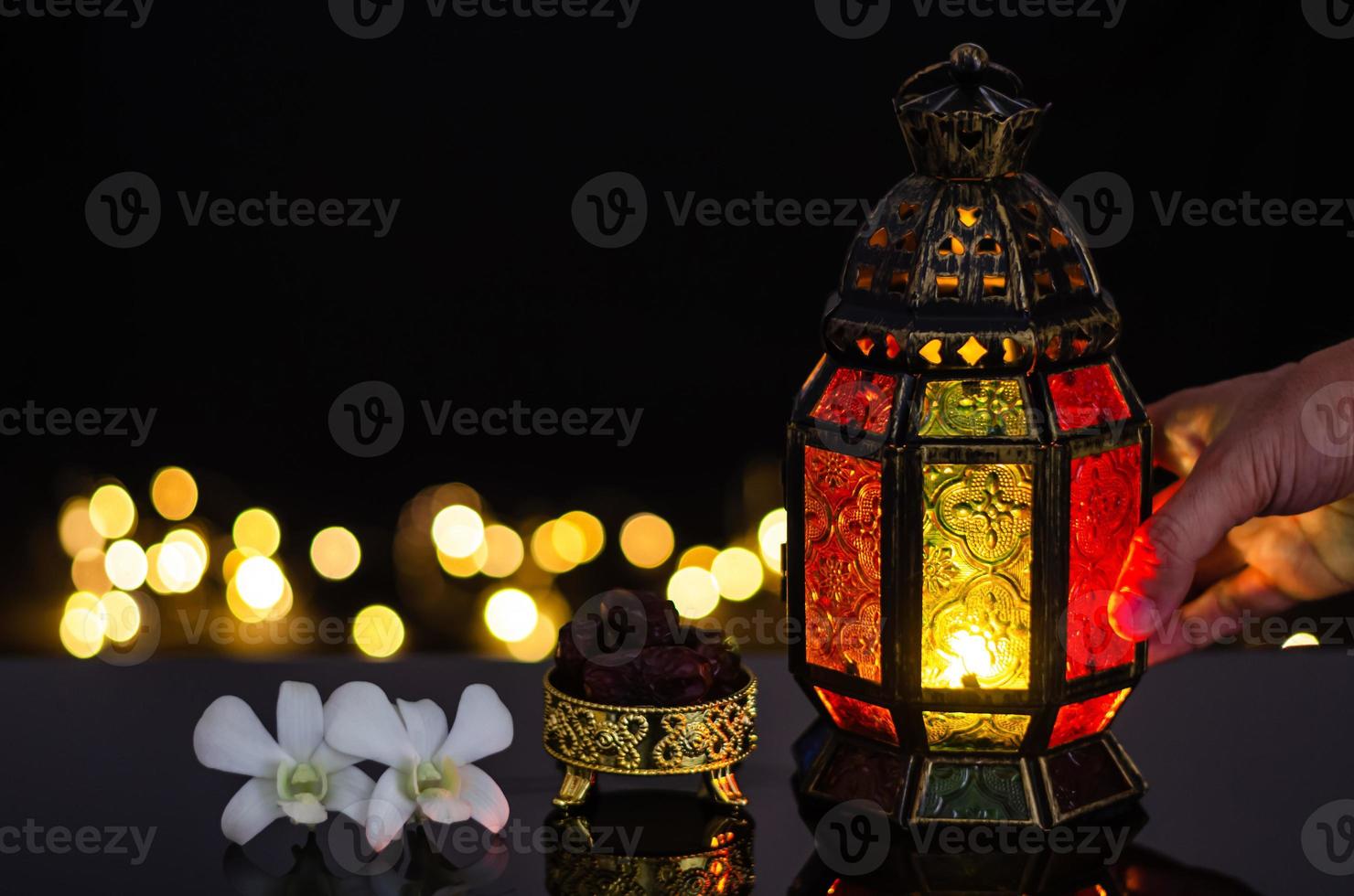 lanterne et fruits de dattes avec fleur d'orchidée blanche sur fond clair bokeh pour la fête musulmane du mois sacré du ramadan kareem. photo