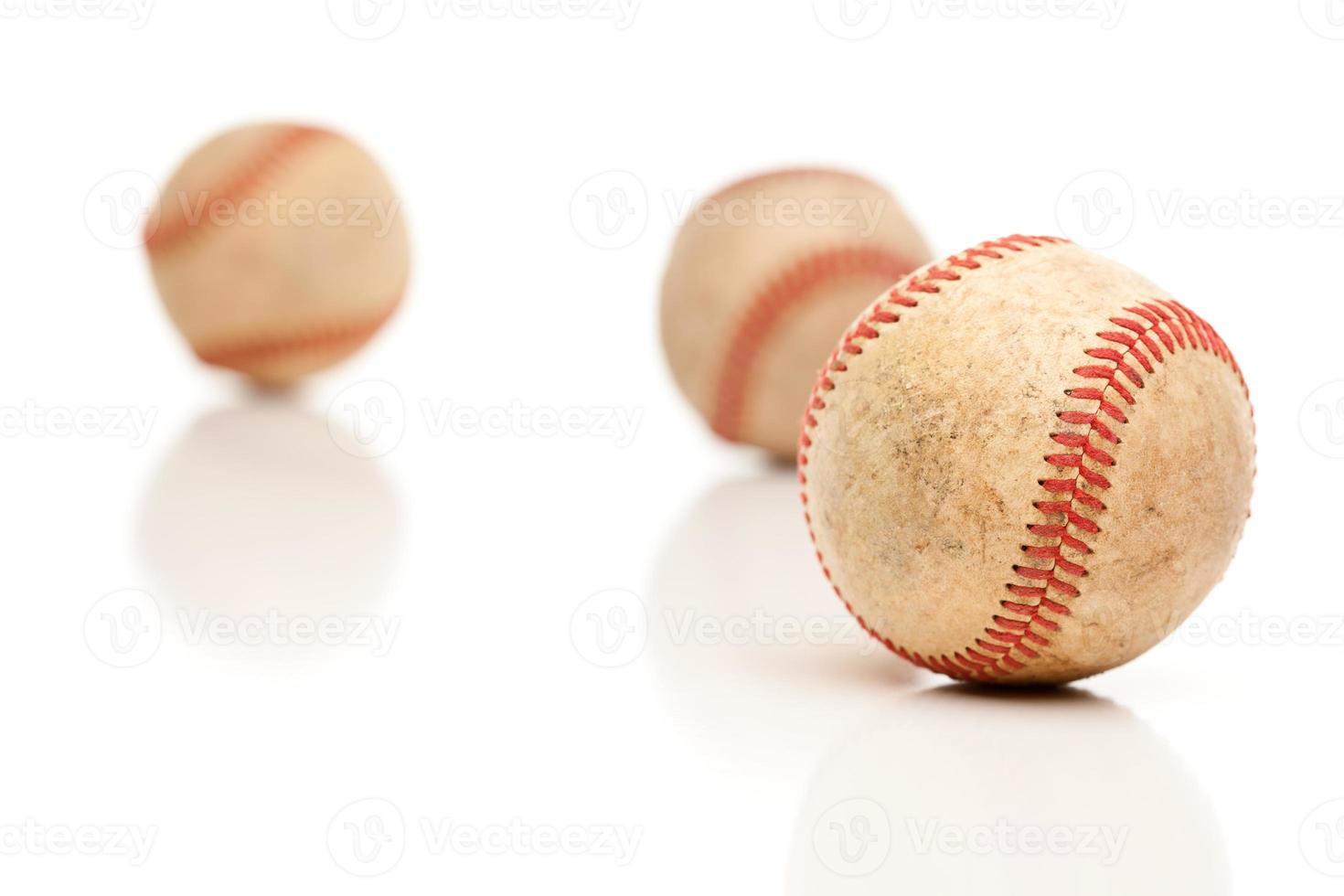 Trois balles de baseball isolées sur blanc réfléchissant photo