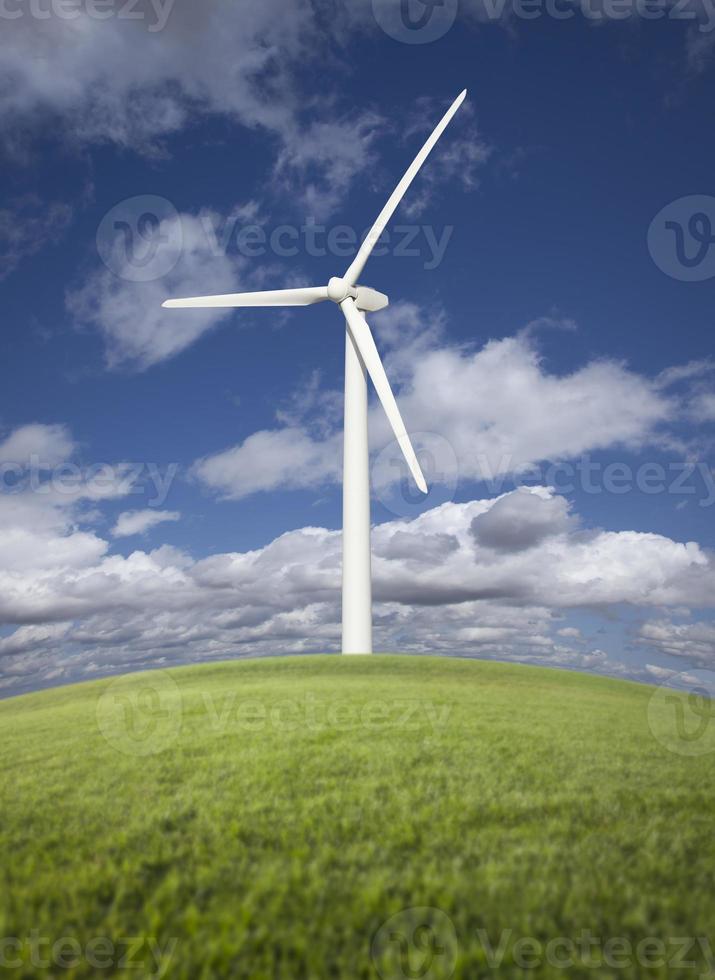 Éolienne sur terrain en herbe, ciel dramatique et nuages photo