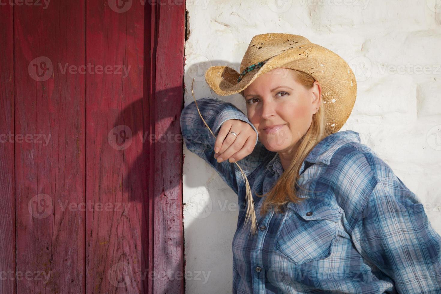 belle cow-girl contre le vieux mur et la porte rouge photo