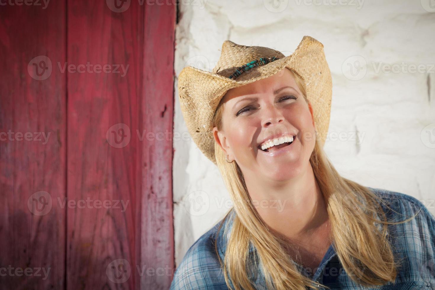 belle cow-girl contre le vieux mur et la porte rouge photo