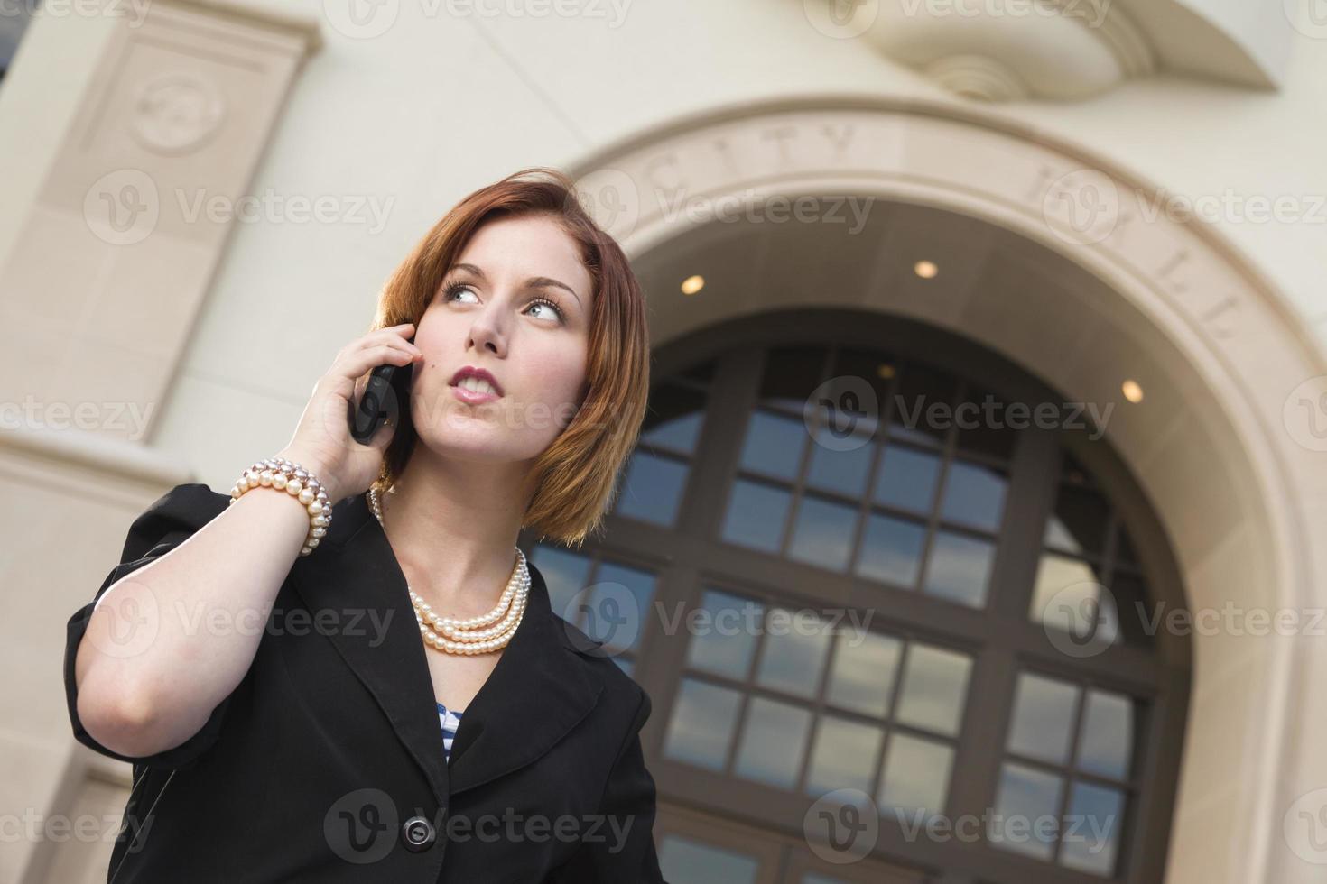 jeune femme d'affaires sur téléphone portable devant l'hôtel de ville photo